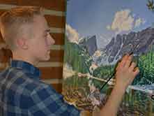 artist putting finishing touches on Hallett Peak painting