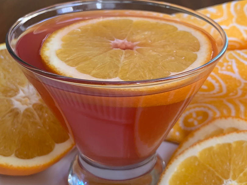 Closeup of a mocktail cosmo with an orange slice