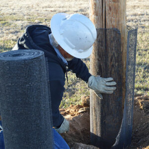 PVREA Lead Lineman Mike Lindenthal installs a fire retardant net barrier on a power pole.