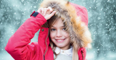 young girl in a pink parka coat
